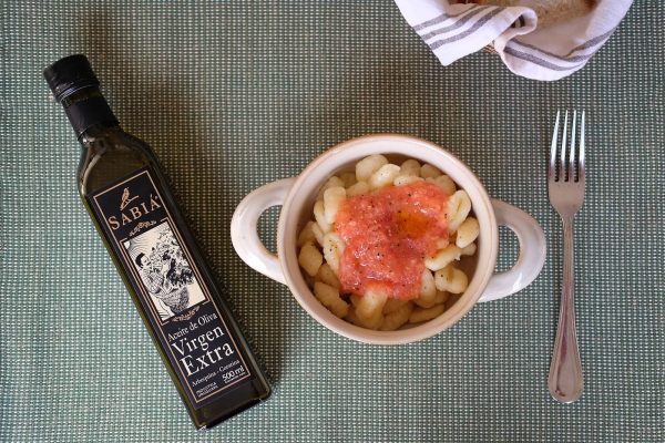 Botella de Sabiá Bivarietal junto a un plato de ñoquis